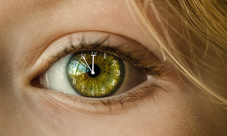 close up edited photo of woman's left eye with analog clock