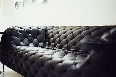 selective focus photo of black leather padded chesterfield sofa