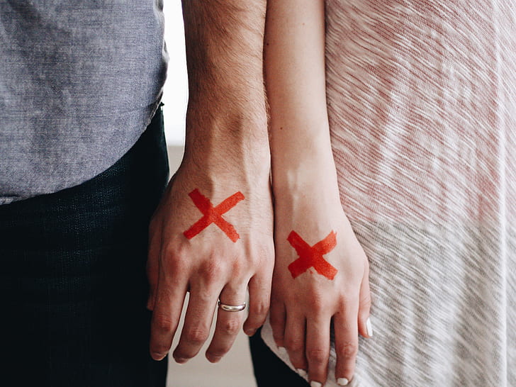 man and woman wrote X mark on their hands