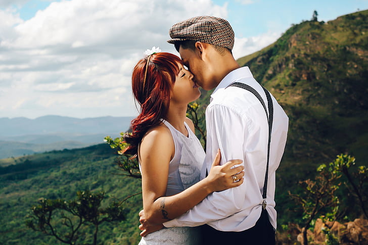 man and woman kissing and view of mountain