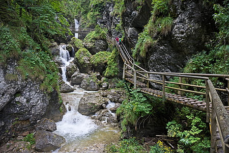 brown wooden bridge near waterfalls