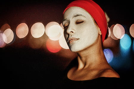 bokeh photography of woman wearing white facial mask