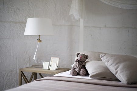 amigurumi bear doll on white bed sheet