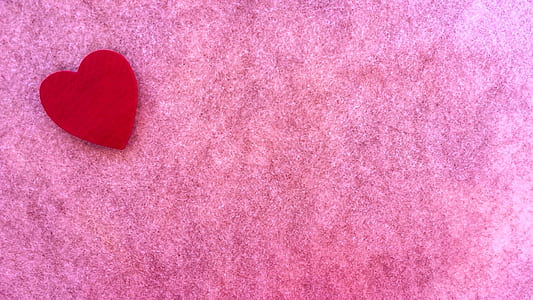 red heart cutout paper on pink background