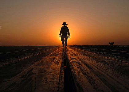 silhouette of man walking during golden hour