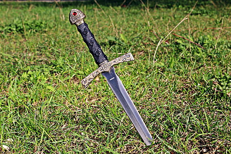 black and grey sword in green grass