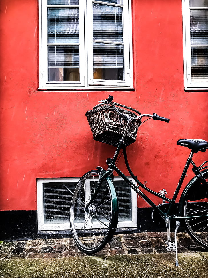 black city bicycle beside red wall