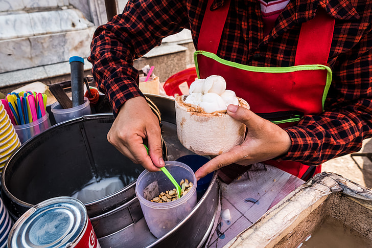 Serving fresh coconut ice cream in young coconut