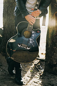 Man Holding Single Cutaway Acoustic Guitar