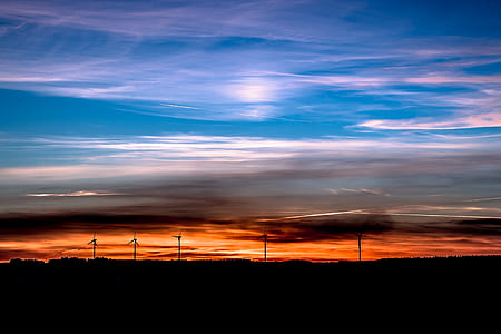 silhouette of five turbines during golden hour