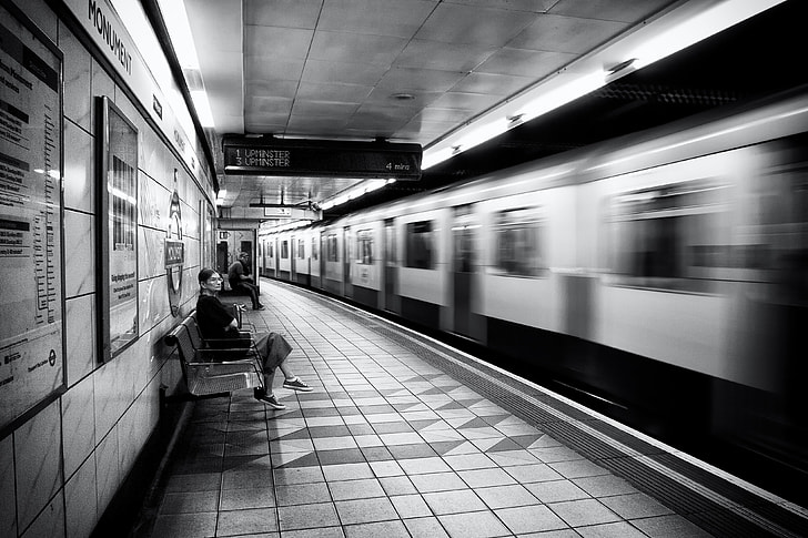 A woman waits on the platform as the train arrives on the London Underground