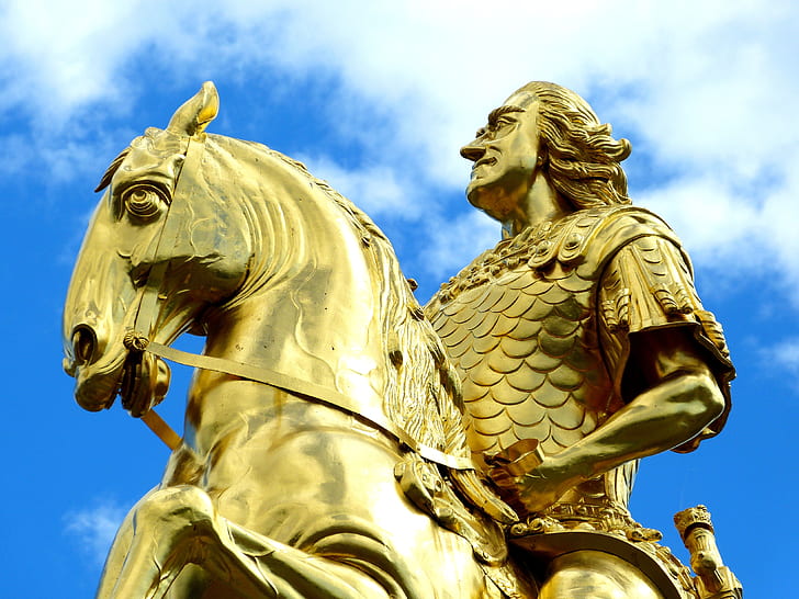 gold-colored man riding on horse statue