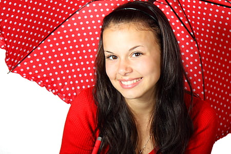 woman holding red and white polka-dot umbrella