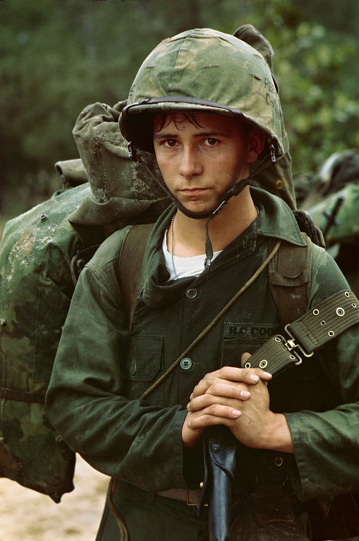 man wearing military helmet and uniform while carrying bag