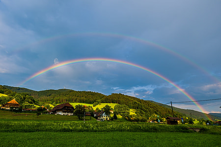 photo of rainbow over village during daytime