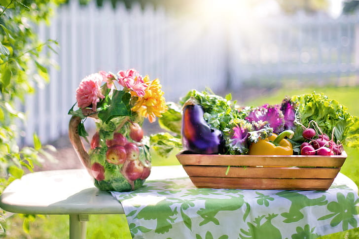 petaled on vase beside vegetables on the basket