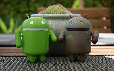 two green and gray Android figurine beside gray flowerpot