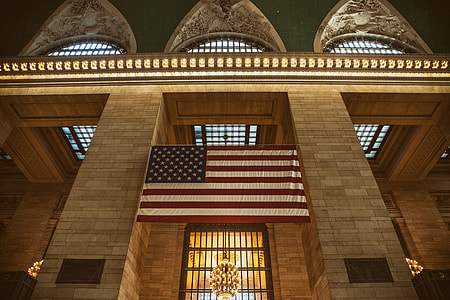 Interior shot containing USA flag taken at Grand Central Station in Manhattan, New York City