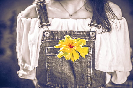 selective color photo of yellow petaled flower on person's romper