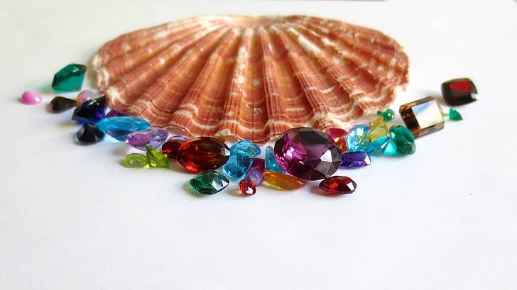 assorted gemstones beside brown seashell