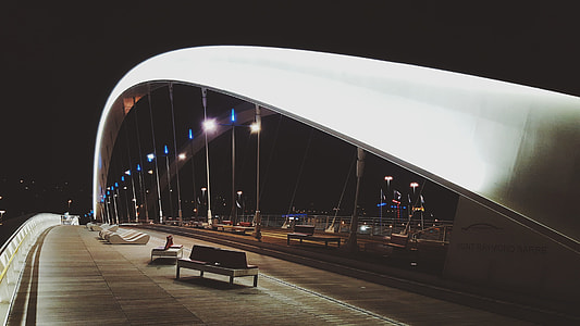 white and black fabric bench on bridge at nighttime