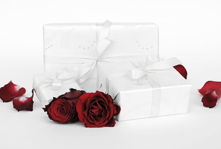 three white wrapped gift boxes and roses