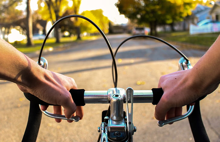 person riding on bicycle on concrete road