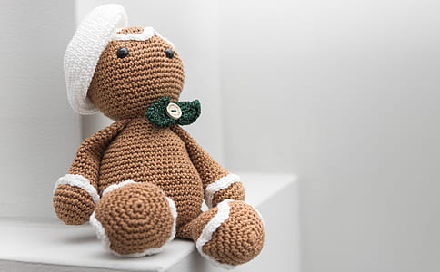 brown bear amigurumi doll on white wooden table