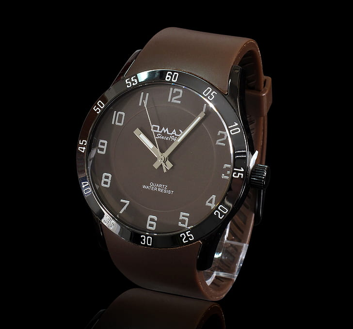 photo of round black analog watch with brown leather strap