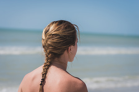 selective focus photography of woman with braided hair standing near beach during daytime