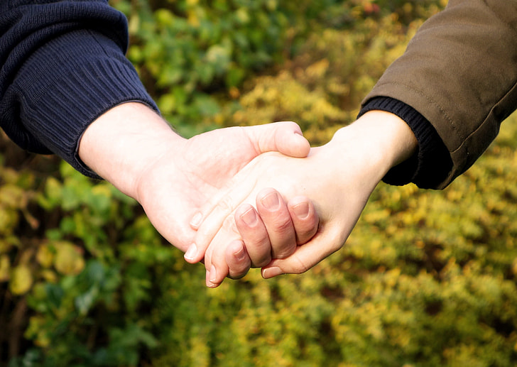 man and woman holding hands photograph