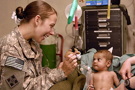 baby with dextrose sitting on sofa near woman wearing soldier uniform