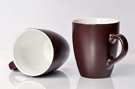 two black-and-white ceramic mugs on white surface