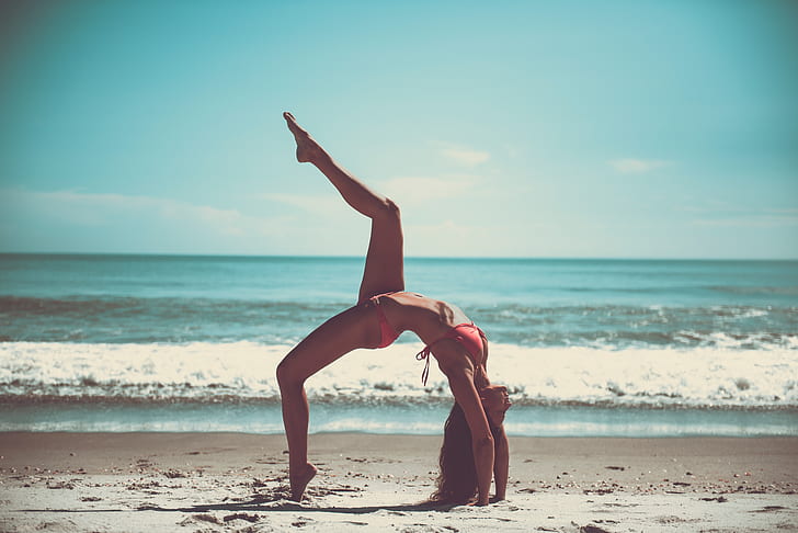 photo of woman bend on sand near beach