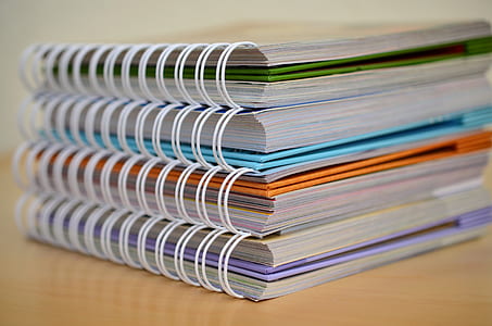closeup photo of assorted-color spiral notebooks