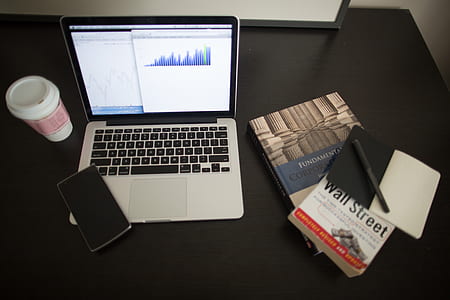 MacBook Pro near several books