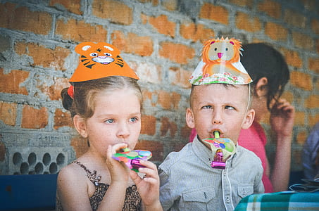 girl and boy wearing animal themed party hats
