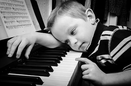 boy leaning on piano keys