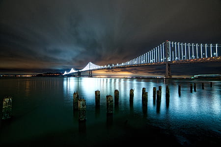 gray concrete bridge near city at nighttime