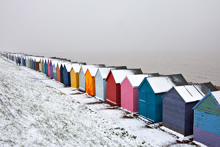 Winter-time snow covered scene of some beach huts on the Kent Coast in England
