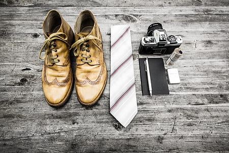 pair of beige boots, grey necktie, and black SLR camera