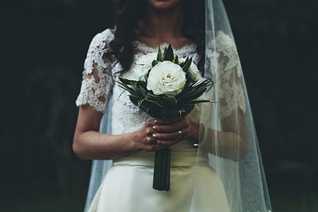 woman wearing wedding dress holding white flower bouquet