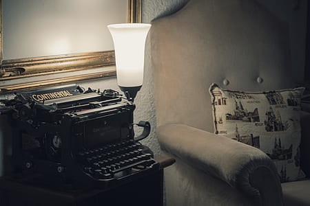 black Continental typewriter on brown wooden end table