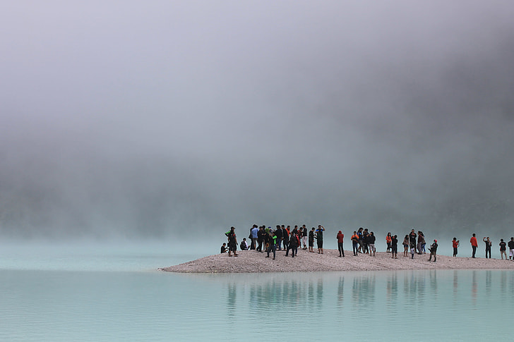 people standing on gray surface on body of water photography