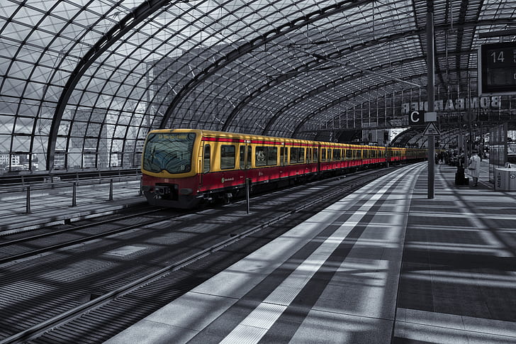 selective color photography of yellow train inside train station