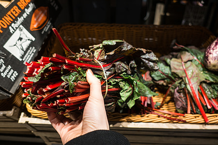 Choosing red swiss chard in a grocery store