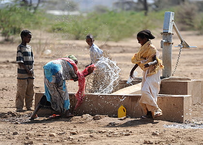 four person playing on water well