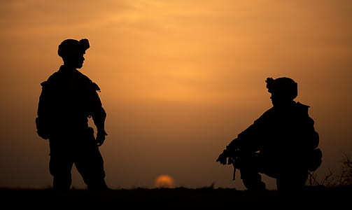 photo of two soldiers during sunset