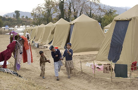 three boy nearby brown tent