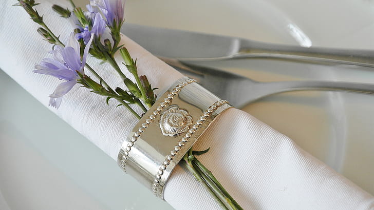 purple petaled flower clipped by silver-colored napkin ring